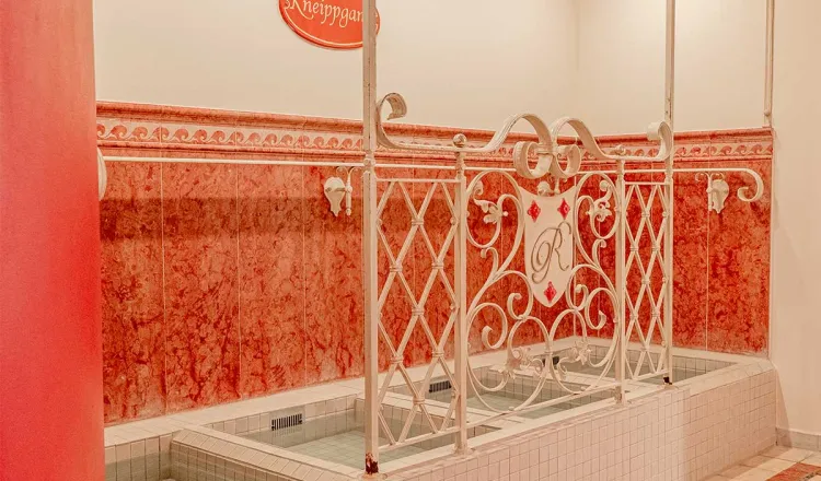 Kneipp-Wassertretbecken mit verspieltem Metallgelände im Wellnessbereich im Hotel mit Sauna in Binz auf Rügen.