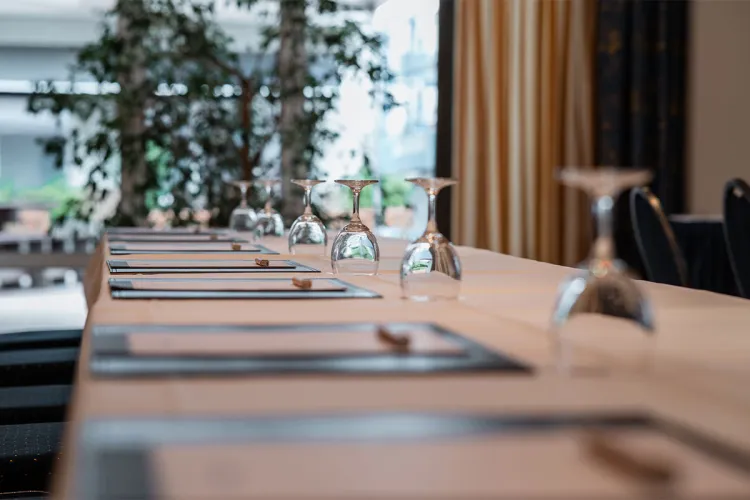 Set conference table with writing pads and upturned glasses in the conference room of the Rugard Thermal Strandhotel.