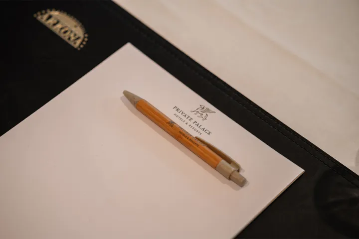 Conference documents with notepad and ballpoint pen on a covered table in the Rugard Thermal Strandhotel.