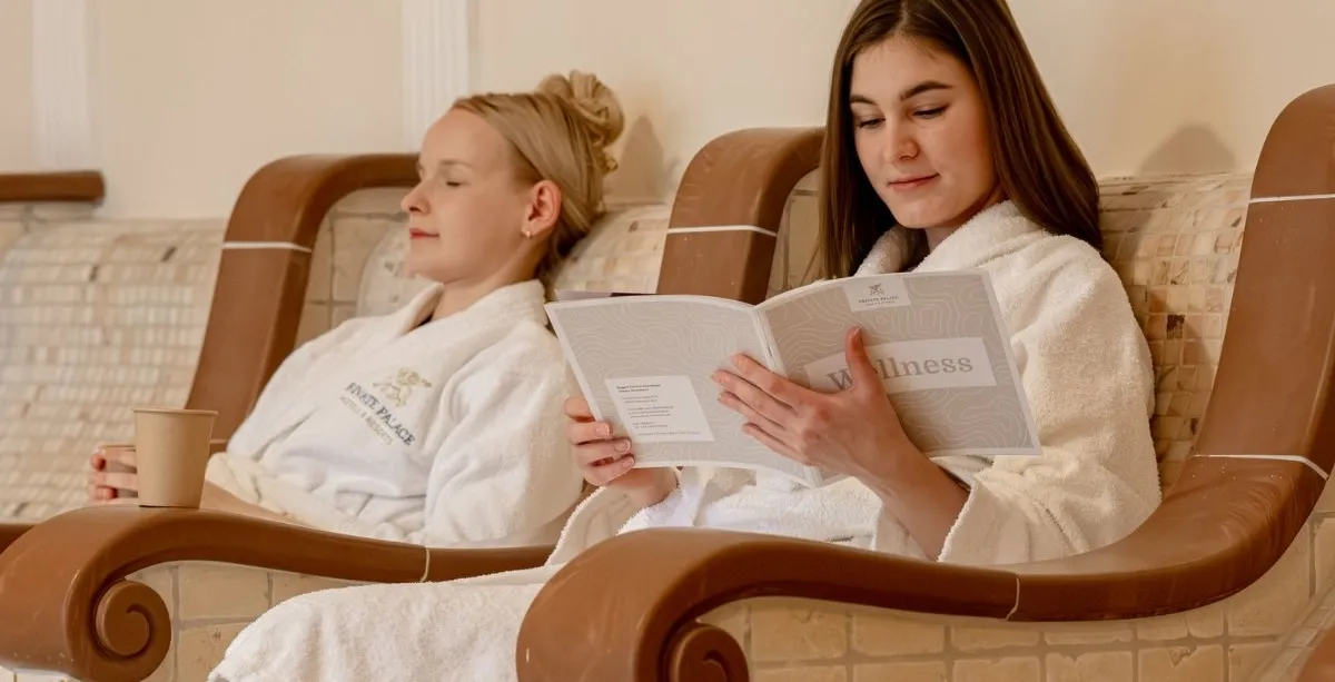 Zwei Gäste entspannen im Wellnessbereich des Rugard Thermal Strandhotels auf beheizten Relaxliegen.