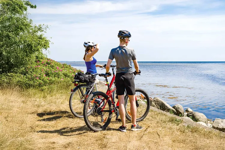 A couple admires the sea view during a cycling trip. Numerous rental options make spontaneous tours easy!