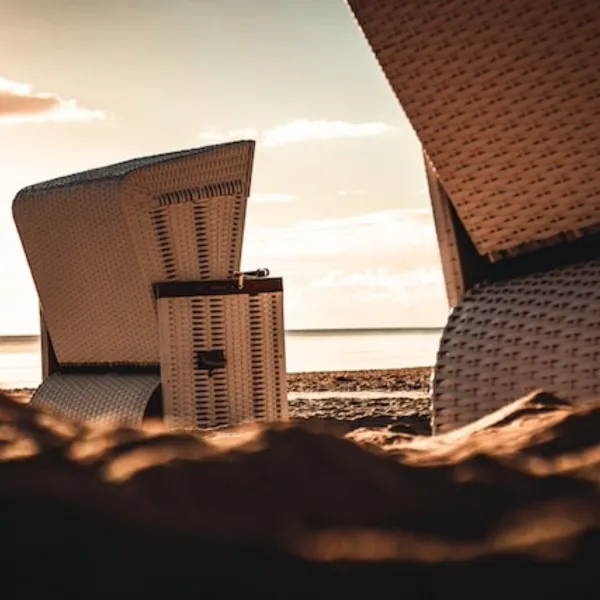 Detailaufnahme von Strandkörben am Ostseestrand bei Sonnenuntergang bei einem Wellnesshotel Angebot.
