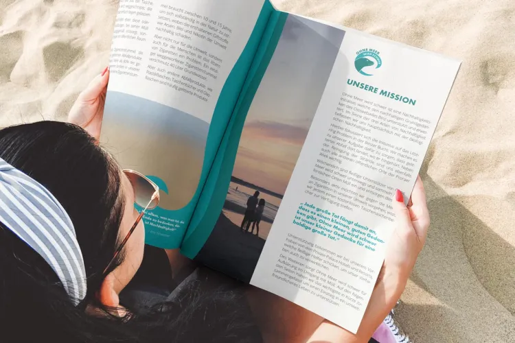 Woman with magazine on the beach of Binz – Rugard Thermal Strandhotel actively supports the "Ohne Meer wird schwer" campaign