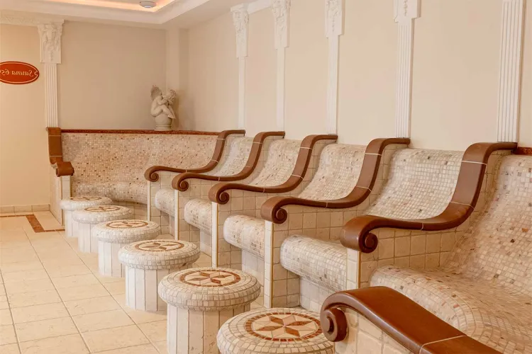 View of heated mosaic loungers with armrests in the quiet tepidarium of the Rugard Thermal Strandhotel.