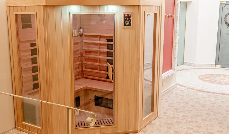 Moderne Infrarotkabine mit Sicht ins Innere steht im lichtdurchfluteten Wellnessbereich in einem Hotel mit Sauna in Binz auf Rügen.