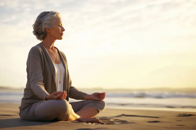 Woman meditating at sunset on the Baltic Sea beach on Rügen during the meditation program at the Rugard Thermal Strandhotel.
