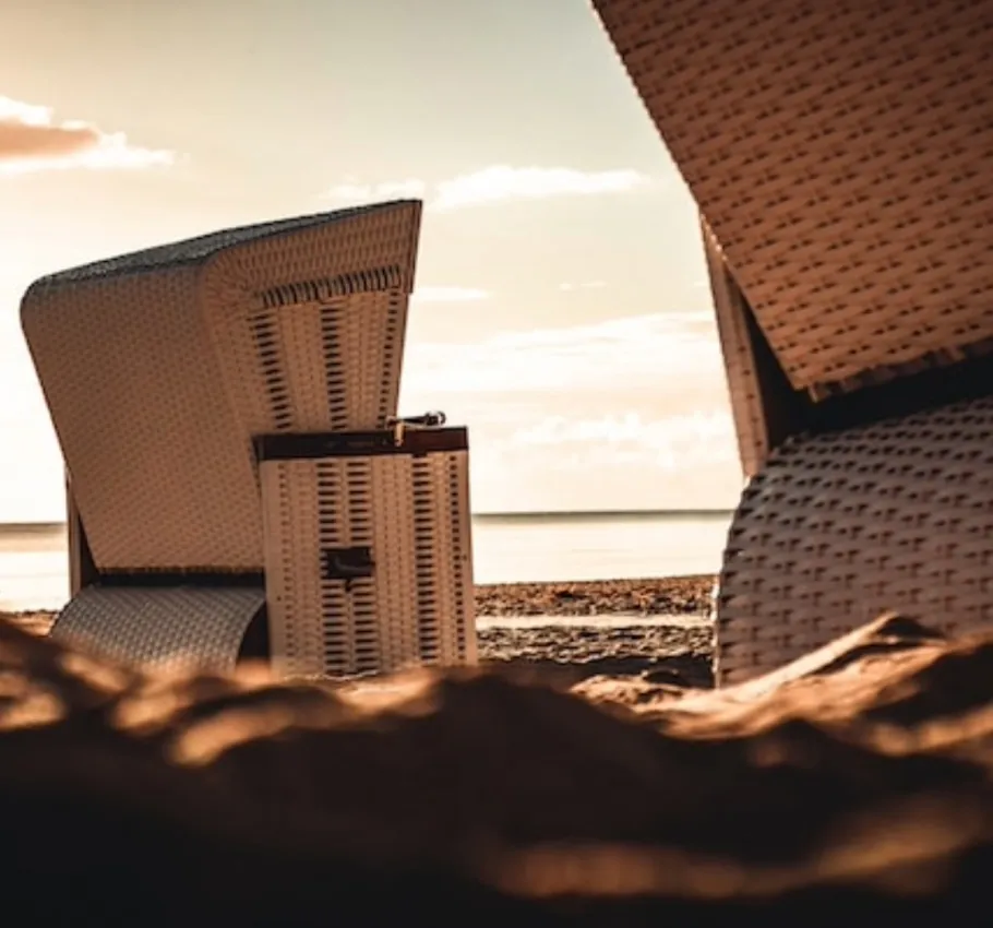 Detailaufnahme von Strandkörben am Ostseestrand bei Sonnenuntergang bei einem Wellnesshotel Angebot.