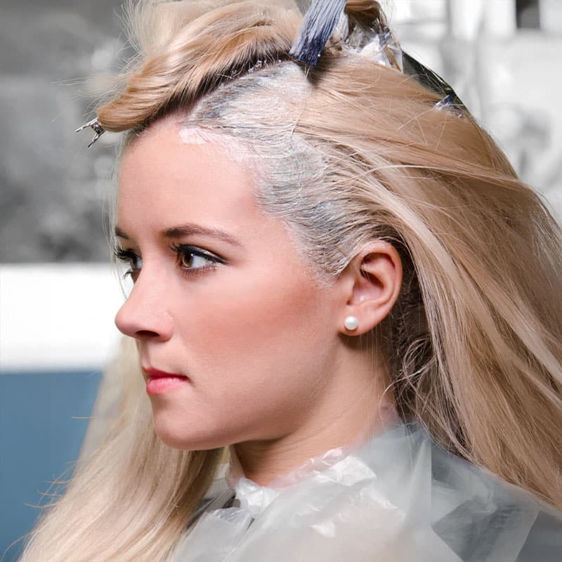 A blonde woman gets a refresher treatment on her hairline.