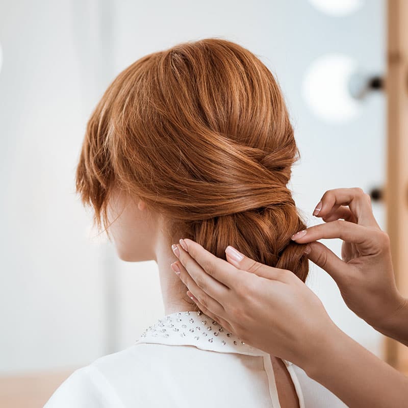Skilfully casual bun hairstyle in long copper-blonde hair.