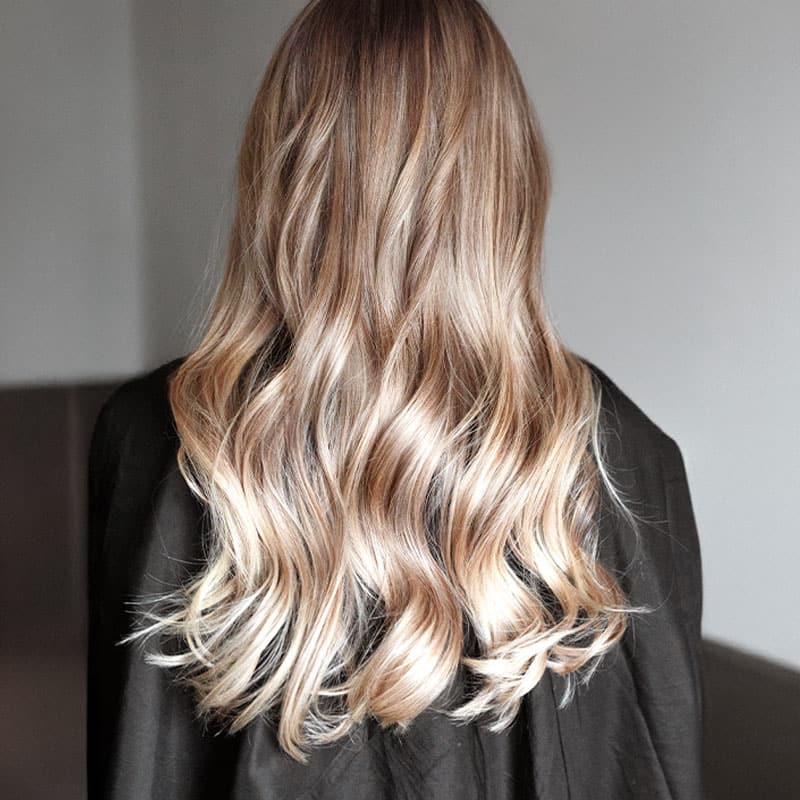 Natural-looking blonde highlights in long, wavy hair.