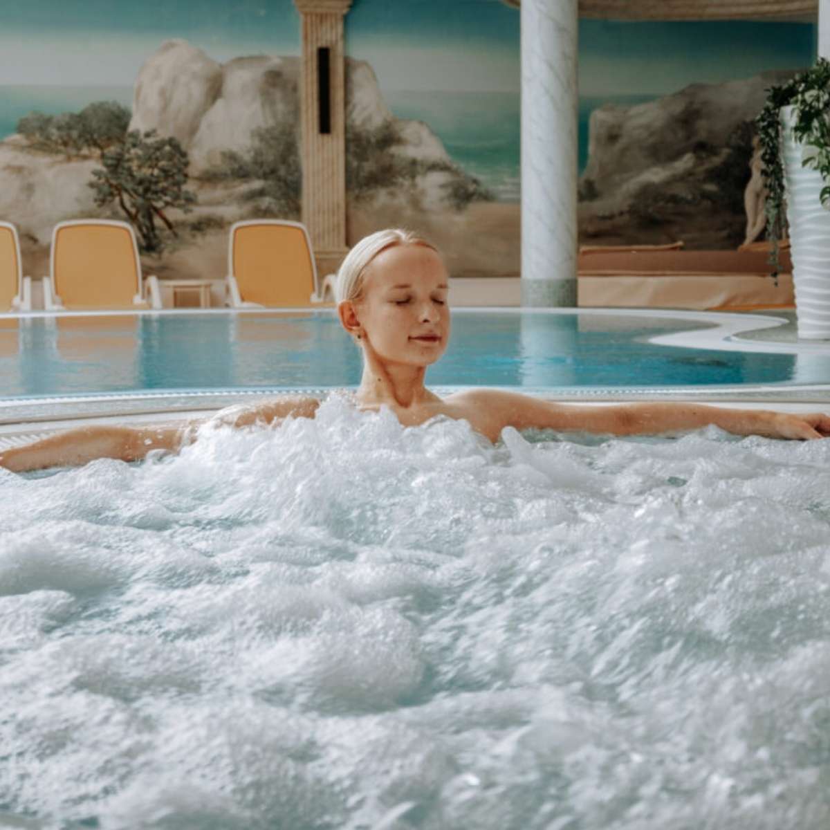 Eine Frau entspannt in einem Whirlpool in einem Wellnesshotel bei einem Angebot an der Ostsee.