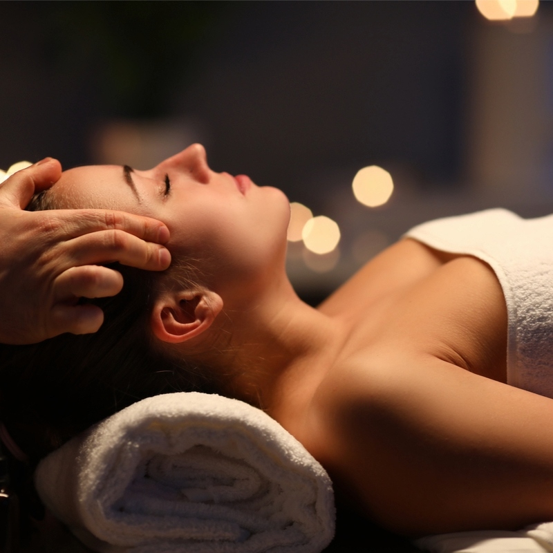 Close-up of a woman receiving a relaxing Ayurvedic head massage.