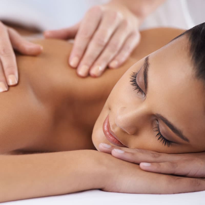 A woman enjoys her massage in the shoulder and neck area.