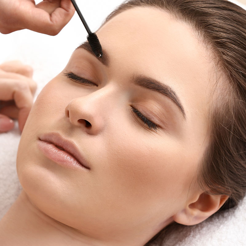 A woman receives a customised eyebrow tint.