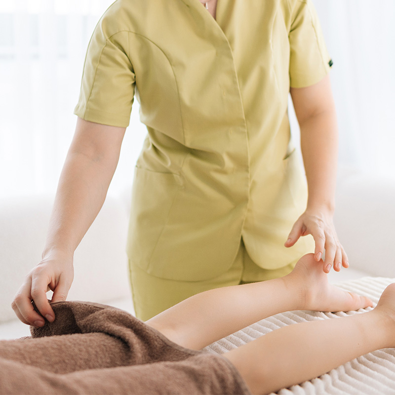 Therapist gently covers a guest’s legs during an aroma oil massage at Arkona Strandhotel Rügen