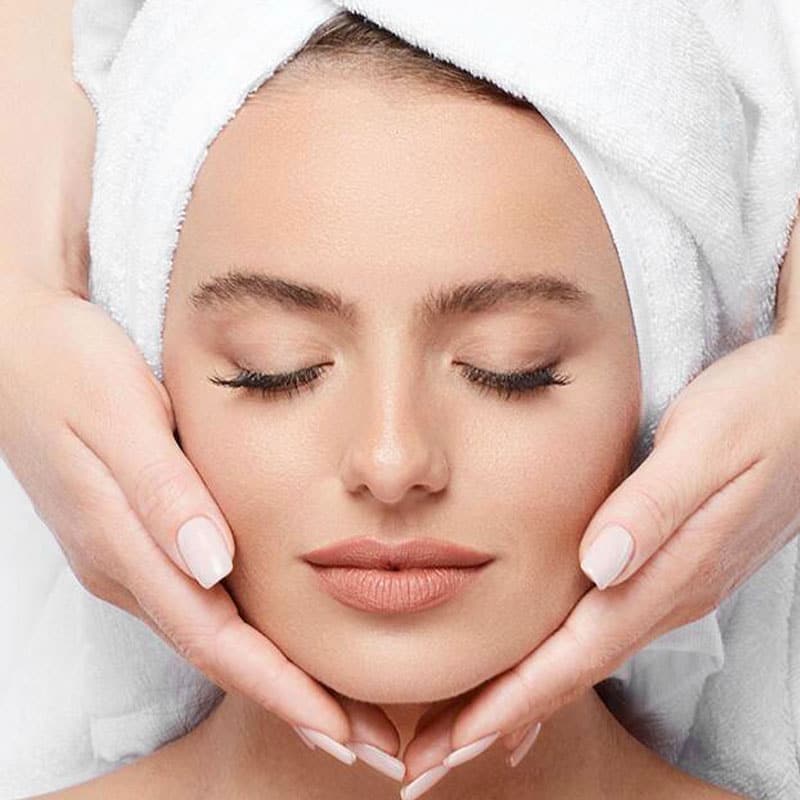 A woman relaxes during a facial massage.
