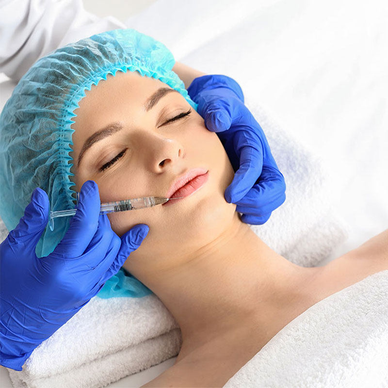 Woman receives hyaluronic filler on her lips through professional application by ÄsthetikaMed at the Arkona Strandhotel on Rügen.