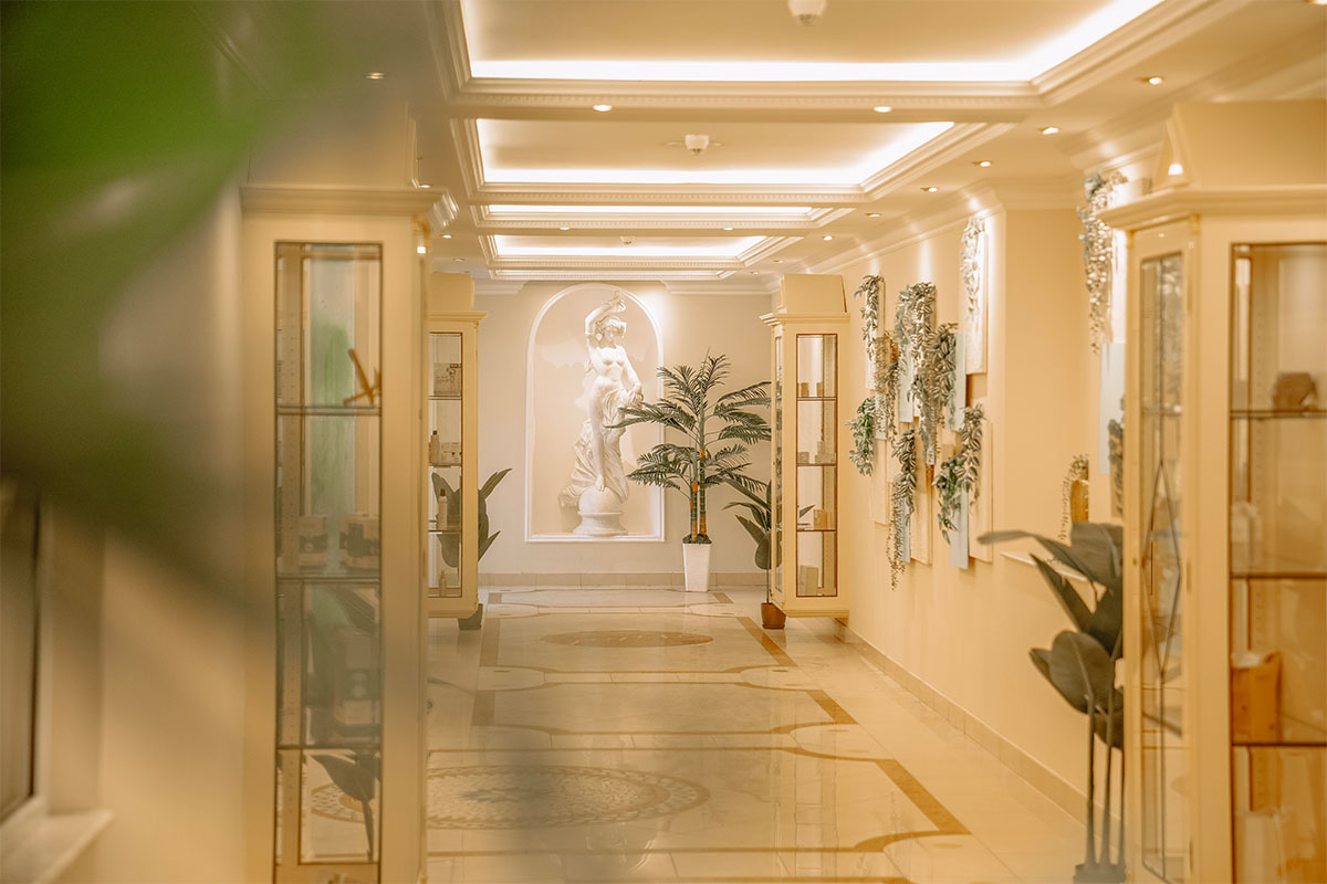 Eleganter Gang im Spa mit Pflanzen und Skulptur im Rugard Thermal Strandhotel in Binz auf Rügen