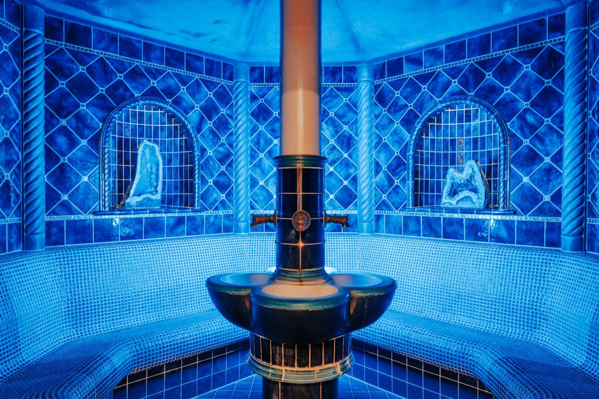 Innenraum der blauen Edelsteingrotte mit runder Sitzbank und Dampfquelle im Hotel mit Sauna in Binz auf Rügen.