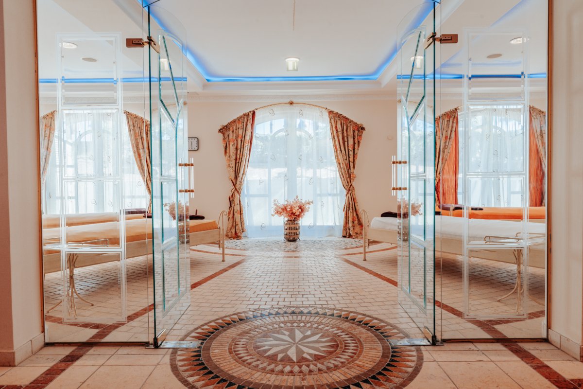Eleganter Ruhebereich mit hellen Liegen, Glastüren und Tageslicht im Spa im Hotel mit Sauna in Binz auf Rügen.