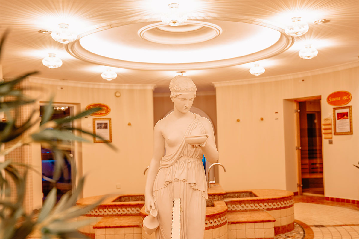 Innenansicht des Spa mit Statue und Brunnen im Wellnessbereich des Rugard Thermal Strandhotels auf Rügen