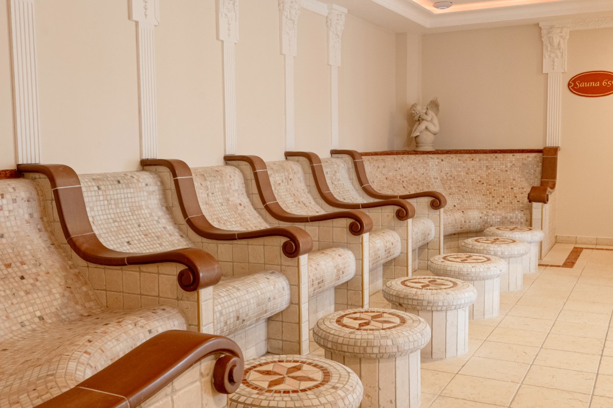 Eleganter Entspannungsraum im Tepidarium mit beheizten Steinliegen im mediterranen Stil des Hotels mit Sauna in Binz auf Rügen.