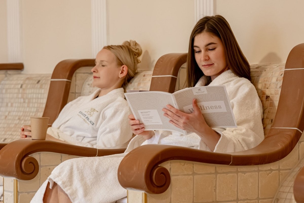 Zwei Gäste entspannen im Wellnessbereich des Rugard Thermal Strandhotels auf beheizten Relaxliegen.